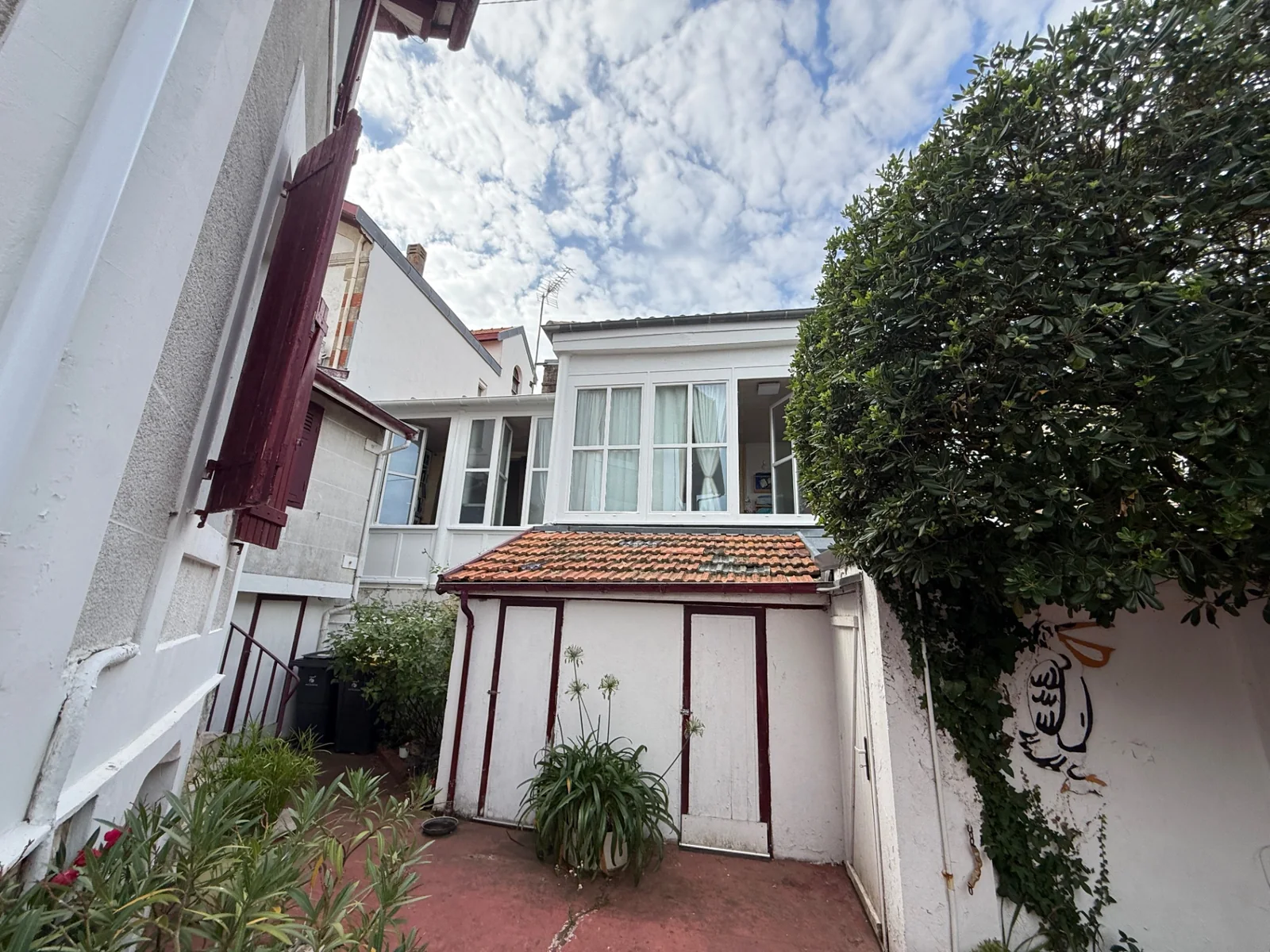 Cour arrière d'une maison à Arcachon montrant les volumes ajoutés au fil des transformations.
